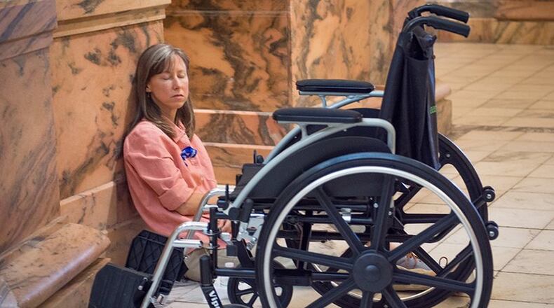 Liz Burlingame of Dunwoody is pictured near her wheelchair at the state Capitol, where a Millions Missing rally was held last year to increase awareness about chronic fatigue syndrome, also known as myalgic encephalomyelitis or ME/CFS. Burlingame, 49, was diagnosed with the disease when she was 24. CONTRIBUTED