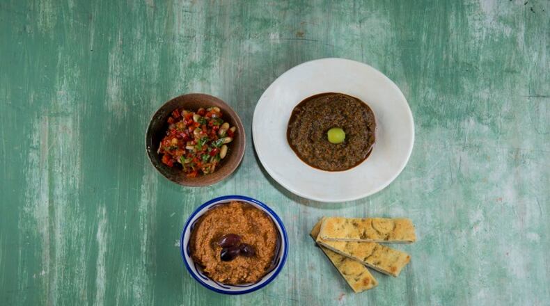 A variety of Persian dips, including piyas (red in brown bowl), hesandin dip (light brown in blue bowl) and riha ezme (dark brown in white bowl). (Jay L. Clendenin/Los Angeles Times/TNS)