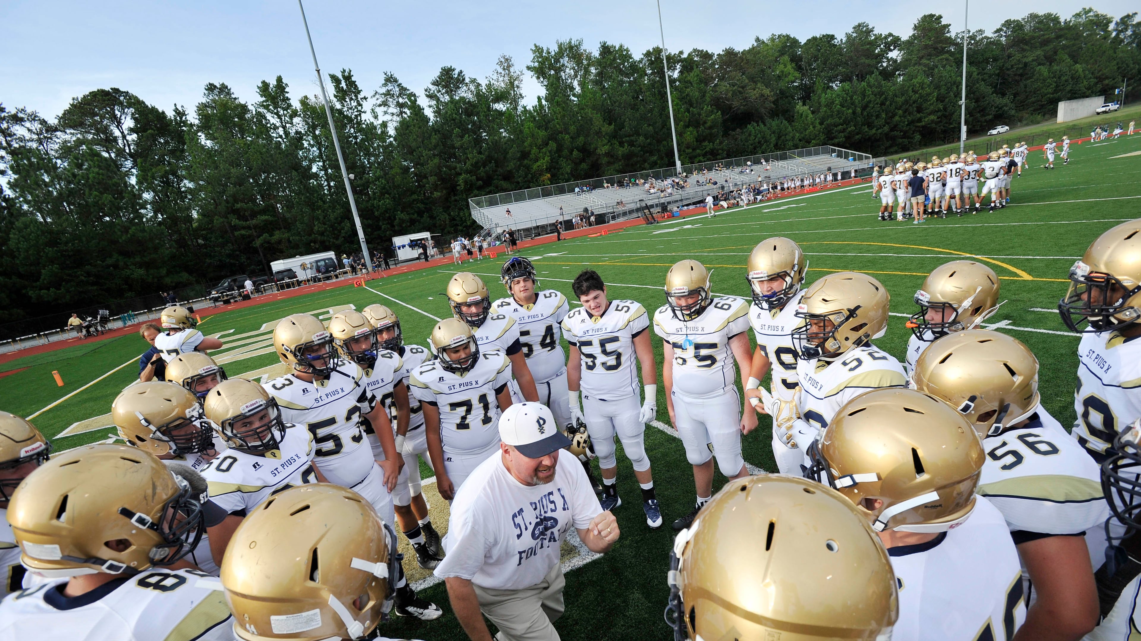 St. Pius football coach Chad Garrison gives a pre-game talk to team members before taking on Blessed Trinity, in Roswell. (John Amis for the AJC 2015)
