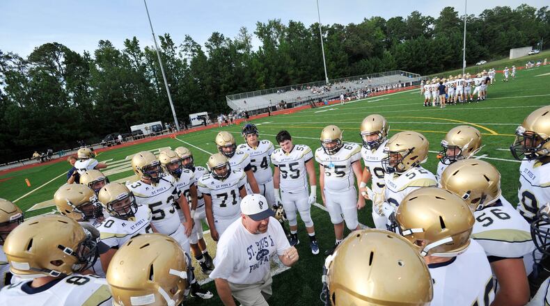 St. Pius football coach Chad Garrison gives a pre-game talk to team members before taking on Blessed Trinity, in Roswell. (John Amis for the AJC 2015)