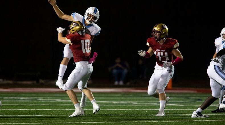 Cambridge quarterback Zach Harris (15) is tackled during a GHSA high school football game between Cambridge High School and Johns Creek High School in Johns Creek, Ga. on Friday, October 15, 2021. (Photo/Jenn Finch)