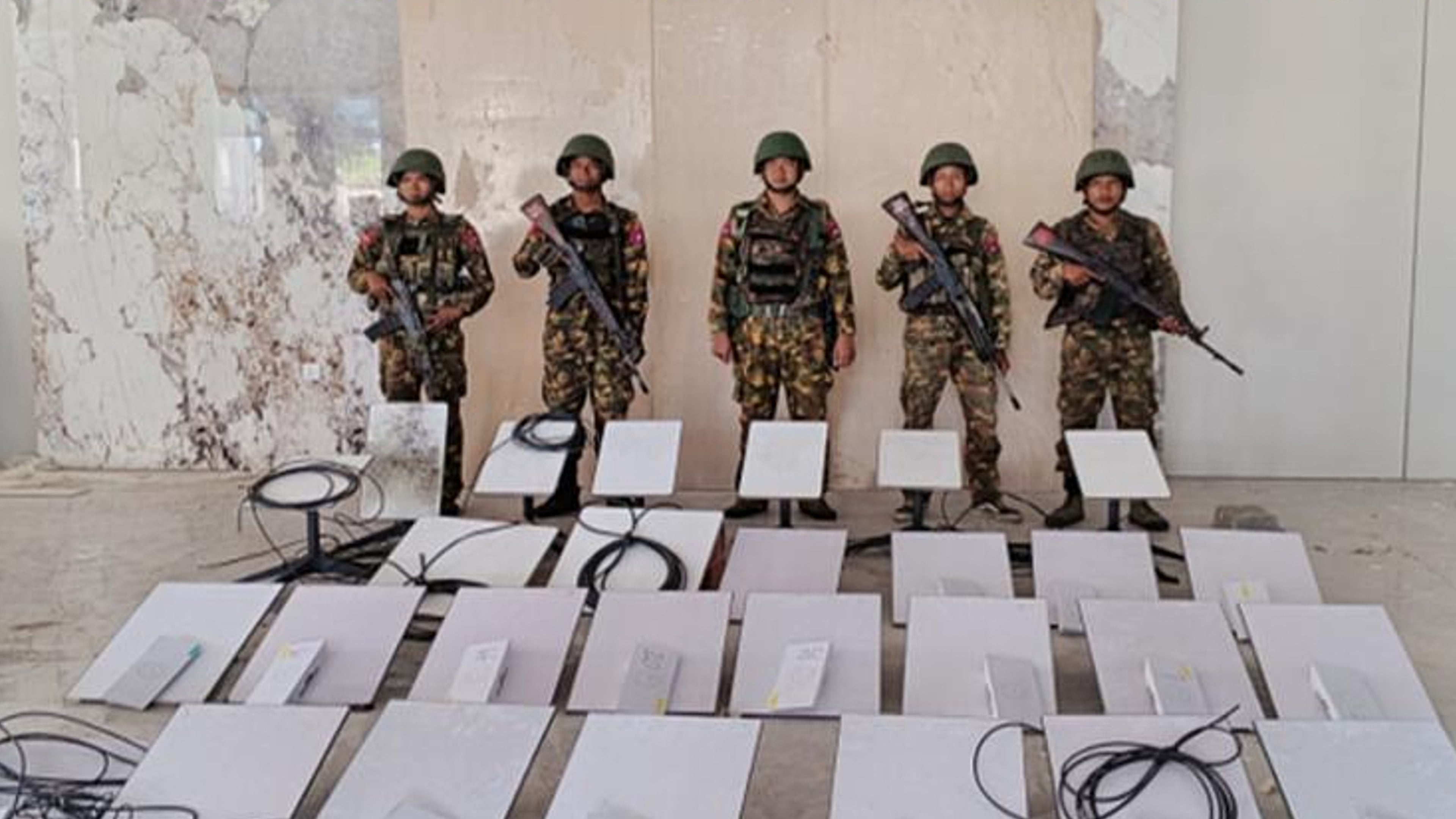 In this image provided by the Myanmar military on Oct. 19, 2025, soldiers stand next to Starlink machines as they seize KK Park online scam center in Myawaddy township, Karen State, Myanmar. (The Myanmar Military True News Information Team via AP)