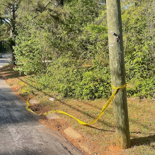 Crime scene tape is tied around a pole near the site where Lauren Bullis was killed, in Panthersville, Ga., Wednesday, April 15, 2026. (AP Photo/R.J. Rico)