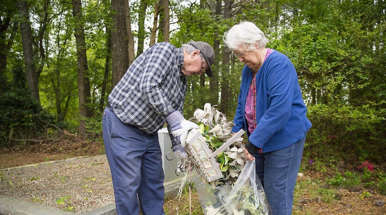 04/18/2019 — Marietta, Georgia — Marvin and Geneva Dunn of Cherokee County clean up their family’s graves at Holly Springs Cemetery, located at 2799 Holly Springs Road, Marietta. The couple heard from a relative about the suspected vandalism at the cemetery and were relieved that Marvin Dunn’s family’s tombstones had not been effected. (ALYSSA POINTER/ALYSSA.POINTER@AJC.COM)
