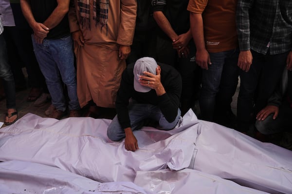 Palestinian mourn their relatives who were killed in an Israeli army airstrike on the Gaza Strip, at the morgue of Al-Aqsa Hospital in Deir al-Balah, Gaza, Tuesday, May 20, 2025. (AP Photo/Abdel Kareem Hana)