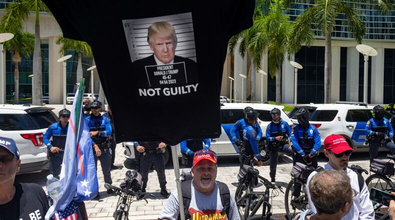A supporter of former President Donald Trump carries a T-shirt as a banner outside the Wilkie D. Ferguson Jr. U.S. Courthouse in Miami, June 13, 2023. (Christian Monterrosa/The New York Times)