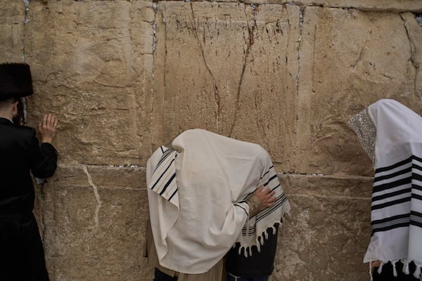 Covered in prayer shawls, Jewish men of the Cohanim Priestly caste participate in a blessing during the holiday of Passover, at the Western Wall, the holiest site where Jews can pray, in the Old City of Jerusalem, Tuesday, April 15, 2025. (AP Photo/Leo Correa)