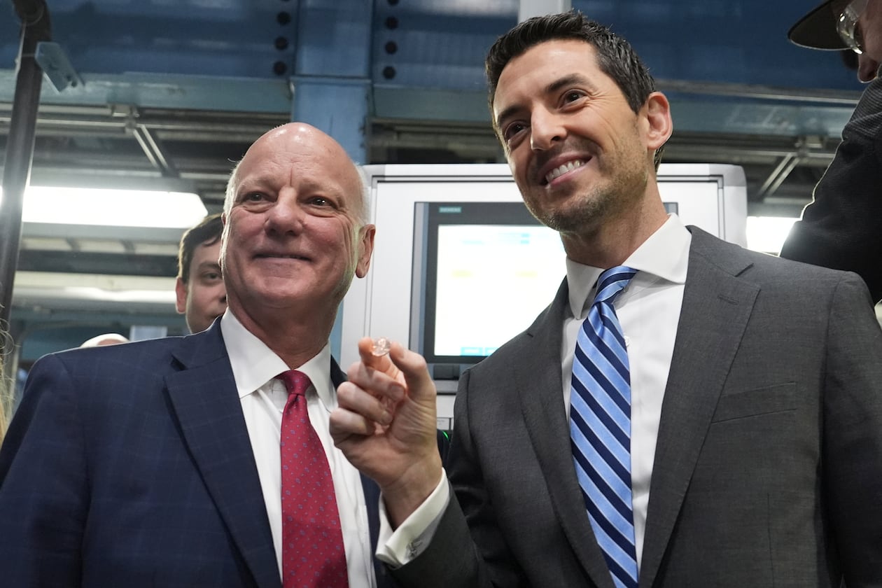 U.S. Treasurer Brandon Beach (left) and Deputy Secretary of the Treasury Derek Theurer pose for a picture holding one of the last pennies pressed at the U.S. Mint in Philadelphia on Wednesday. (Matt Slocum/AP)