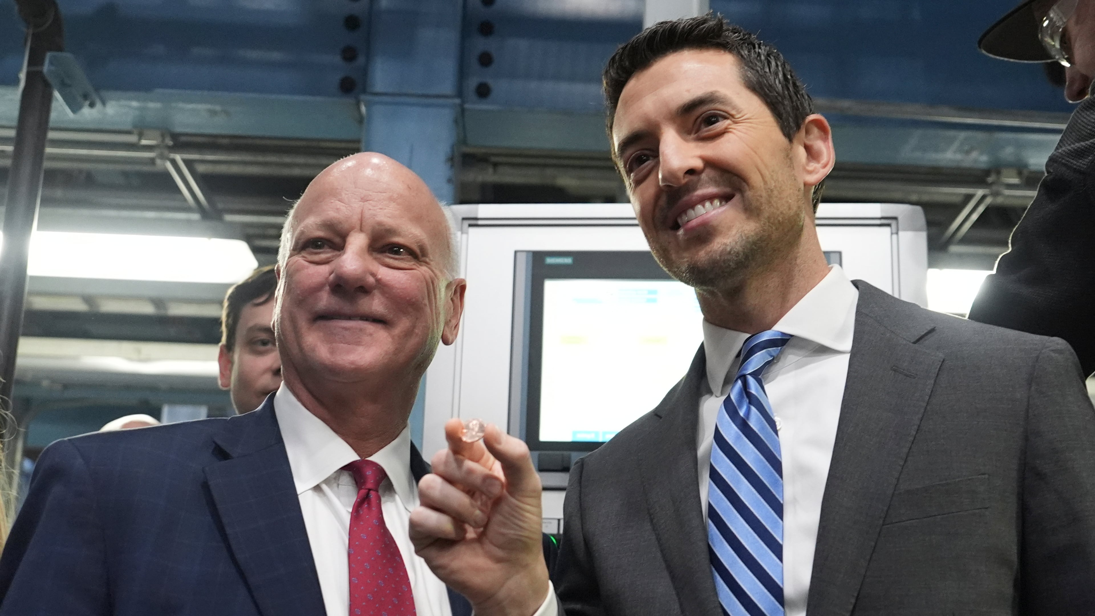 U.S. Treasurer Brandon Beach (left) and Deputy Secretary of the Treasury Derek Theurer pose for a picture holding one of the last pennies pressed at the U.S. Mint in Philadelphia on Wednesday. (Matt Slocum/AP)