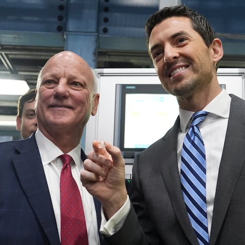 U.S. Treasurer Brandon Beach (left) and Deputy Secretary of the Treasury Derek Theurer pose for a picture holding one of the last pennies pressed at the U.S. Mint in Philadelphia on Wednesday. (Matt Slocum/AP)