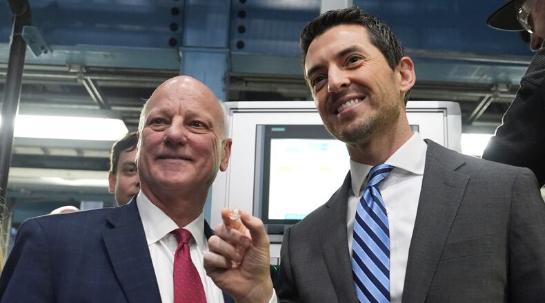 U.S. Treasurer Brandon Beach (left) and Deputy Secretary of the Treasury Derek Theurer pose for a picture holding one of the last pennies pressed at the U.S. Mint in Philadelphia on Wednesday. (Matt Slocum/AP)