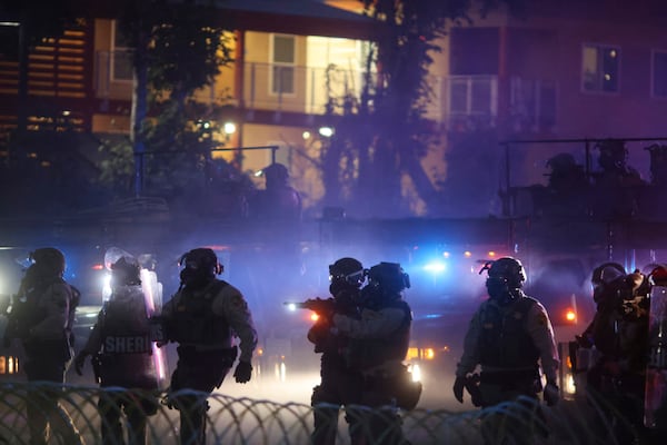 Law enforcement stand during a protest in Compton, Calif., Saturday, June 7, 2025, after federal immigration authorities conducted operations. (AP Photo/Ethan Swope)