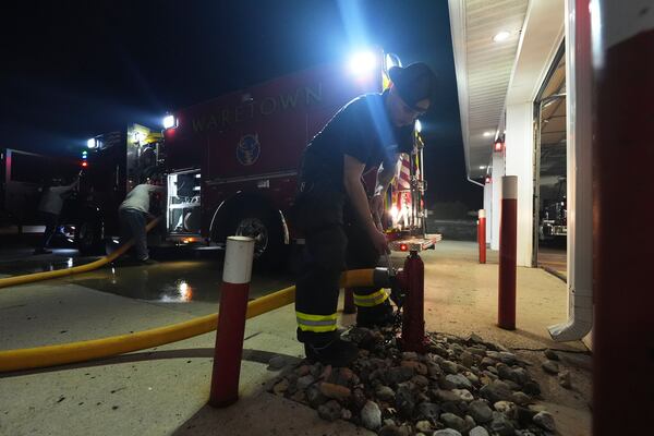 A Waretown volunteer firefighter helps prepare a firetruck to respond to a wildfire on Tuesday, April 22, 2025, in Waretown, N.J. (AP Photo/Chris Szagola)