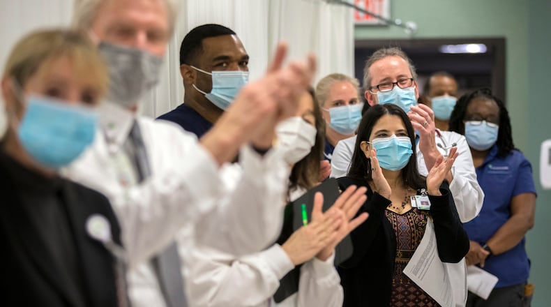 Healthcare professionals at St. Joseph's Candler hospital in Savannah applaud the first nurse to be inoculated at the hospital on Tuesday. Atlanta Power Poll leaders called the vaccine's arrival in Georgia the leading reason why they're optimistic for the coming year. (AJC Photo/Stephen B. Morton)