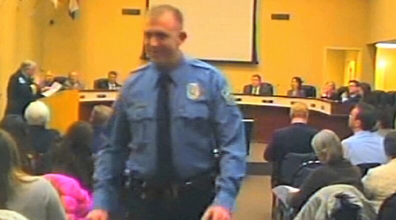 FILE - In this Feb. 11, 2014 file image from video released by the City of Ferguson, Mo., officer Darren Wilson attends a city council meeting in Ferguson. Wilson has told authorities that Michael Brown reached for the gun during a scuffle, the Times reported in a story posted on its website Friday night Oct. 17, 2014. (AP Photo/City of Ferguson, File)