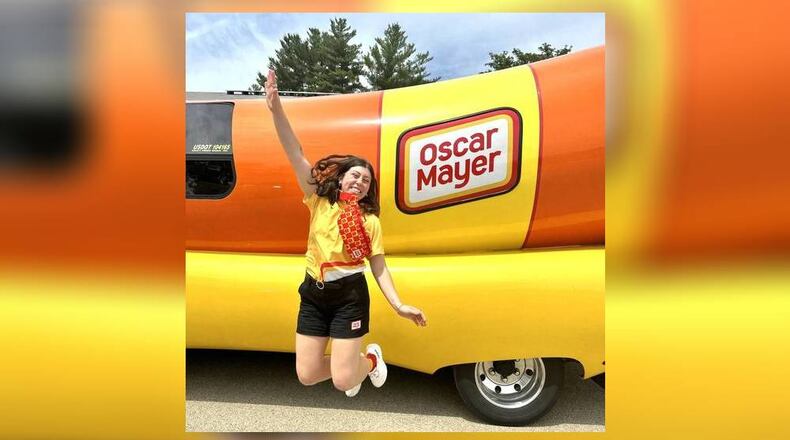 Columbus native Sarah Oney, one of 12 Wienermobile drivers Oscar Mayer selected for the 2024-25 season from more than 7,000 applications, jumps for joy during a practice event June 2024 in Darlington, Wisconsin. (Photo provided by Sarah Oney)