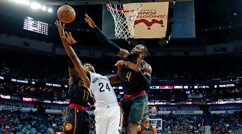 New Orleans Pelicans guard Buddy Hield (24) goes to the basket against Atlanta Hawks guard Dennis Schroder (17) and forward Paul Millsap (4) in the second half of an NBA basketball game in New Orleans, Thursday, Jan. 5, 2017. The Hawks won 99-94. (AP Photo/Gerald Herbert)