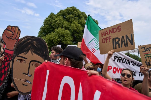 A woman holds a placard during a demonstration ahead of the NATO summit in The Hague, Netherlands, Sunday, June 22, 2025. (AP Photo/Peter Dejong)