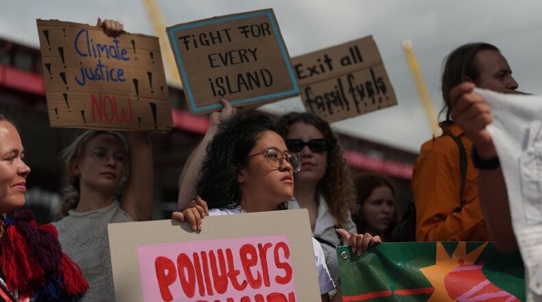ADDS NAME - Rachelle Junsay, center, stands with other activists participating in a youth climate demonstration during the COP30 U.N. Climate Summit, Friday, Nov. 14, 2025, in Belem, Brazil. (AP Photo/Joshua A. Bickel)