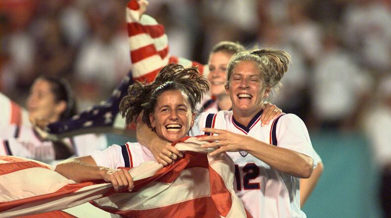 Joy Fawcett (left) and Carin Gabarra (right) run around Sanford Stadium in Athens with an American flag after their historic 2-1 gold medal win over China Thursday, Aug. 1, 1996, during the 1996 Summer Olympic Games. (David Tulis/AJC)