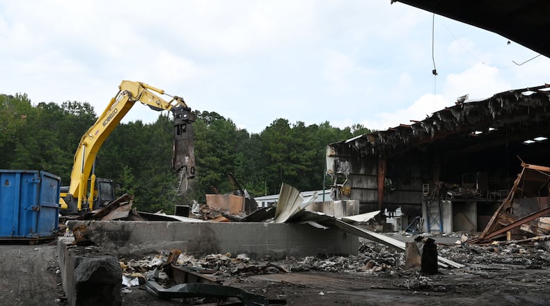 Metro Site employees work on demolition and clean-up at their recycling facility that burned down last summer in Commerce. (Hyosub Shin / Hyosub.Shin@ajc.com)