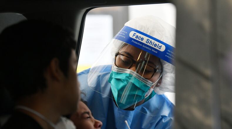 April 28, 2020 Gainesville - A child cries as a medical professional attempts to collect a nasal swab at a drive-through COVID-19 testing site at Good News Clinic in Gainesville on Tuesday, April 28, 2020. Northeast Georgia Health System partnered with Good News Clinic tested over 300 Hall County adults and children for COVID-19. Cars stretched in lines around the Good News Clinic. (Hyosub Shin / Hyosub.Shin@ajc.com)
