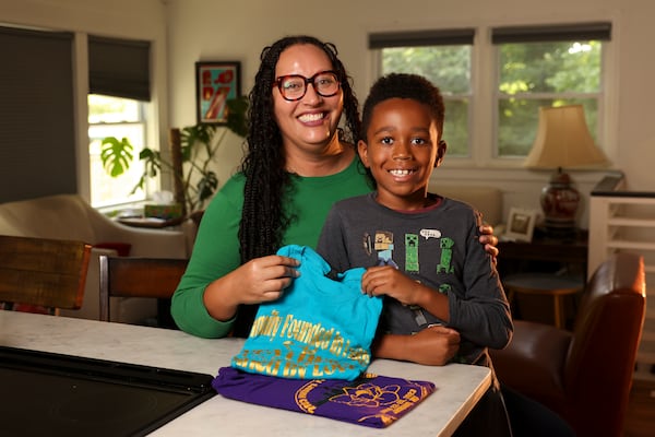 Sheeka Sanahori and her son Amir Sanahori, 8, hold T-shirts from  recent Weathers family reunions. (Jason Getz/AJC)