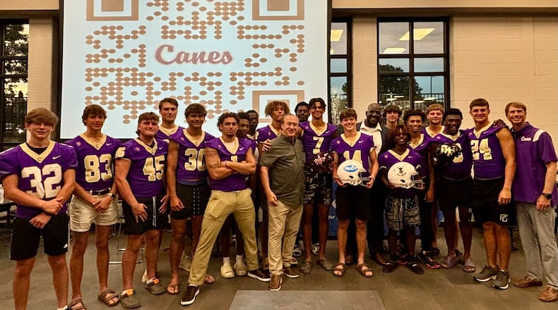 The Cartersville football team shows off the new helmet covers it will wear this season. The Purple Hurricanes are getting customized covers with the school logo to wear in practice and games.