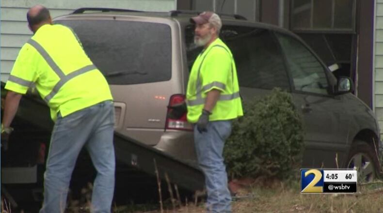 Workers remove a van after it crashed into a house in Fayette County.