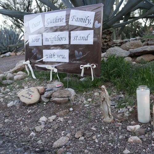 Lit candles next to a sign from neighbors supporting the Guthrie family outside of Nancy Guthrie’s house in the early morning hours of Sunday, Feb. 8, 2026 in Tucson, Ariz. (AP Photo/Ty ONeil)