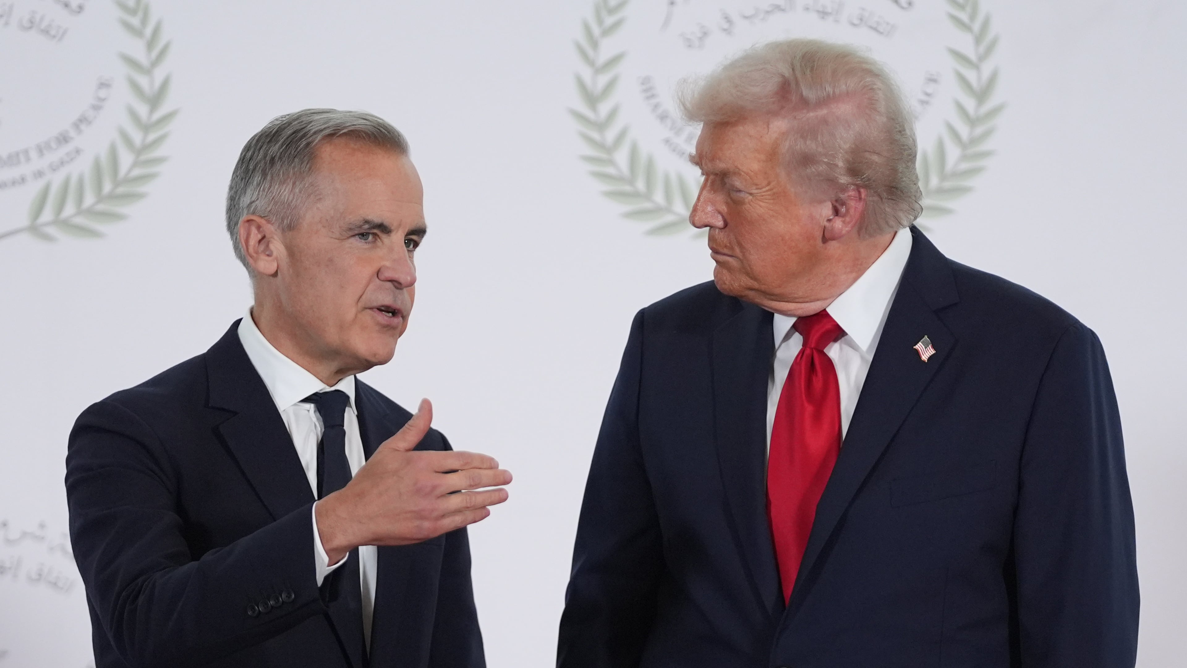 President Donald Trump greets Canada's Prime Minister Mark Carney during a summit to support ending the more than two-year Israel-Hamas war in Gaza after a breakthrough ceasefire deal, Monday, Oct. 13, 2025, in Sharm El Sheikh, Egypt. (AP Photo/Evan Vucci, Pool)
