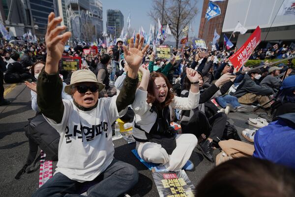 People react after hearing the news that President Yoon Suk Yeol was removed from office, in Seoul, South Korea, Friday, April 4, 2025. (AP Photo/Lee Jin-man)