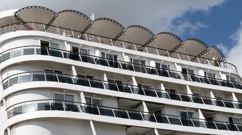 Passengers stand aboard the British cruise ship Ambition, as French authorities have ordered 1,700 passengers and crew to stay on board due to a gastrointestinal illness outbreak, in Bordeaux, southwestern France, Wednesday, May 13, 2026. (AP Photo/Caroline Blumberg)
