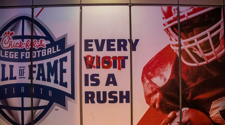 Protestors used spray paint to add graffiti at the College Football Hall of Fame in Atlanta. (ALYSSA POINTER / ALYSSA.POINTER@AJC.COM)
