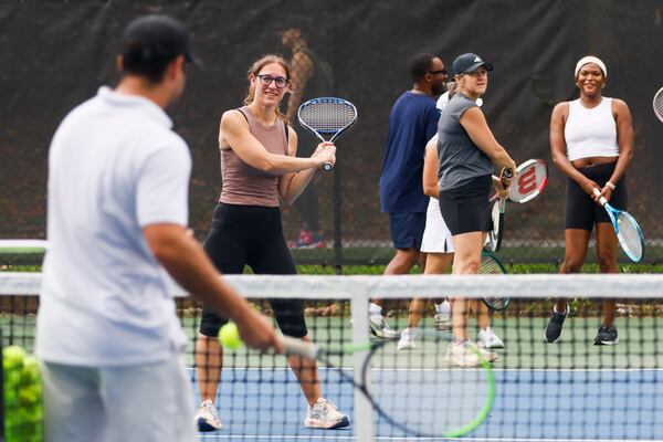 Valentino Caratini (far left, back to camera), CEO and co-founder of Hazlo, teaches a clinic to players at the Glenlake Tennis Center on Saturday, May 30, 2026, in Decatur. Caratini competed on the junior circuit before pursuing a collegiate career at Georgia Gwinnett College. (Abbey Cutrer/AJC)