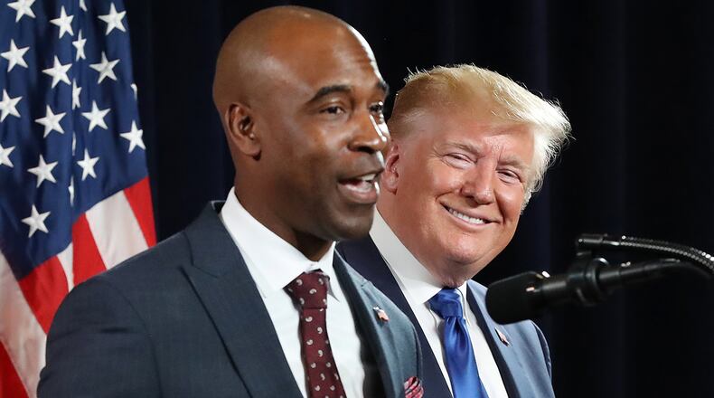 President Donald Trump looks on while business owner Kelvin King joins him on stage to speak during the Black Voices for Trump Coalition Rollout in Atlanta in November 2019. Curtis Compton/ccompton@ajc.com