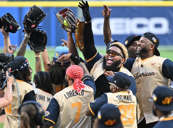 Comedian and actor Druski (center right, with sunglasses) and other American League players celebrate their win in the MLB All-Star Celebrity Softball Game at Truist Park on Saturday, July 12, 2025, in Atlanta. (Hyosub Shin/AJC)