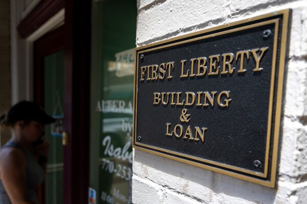 A person walks into the store next to First Liberty Building & Loan in downtown Newnan last year. (Arvin Temkar/AJC)
