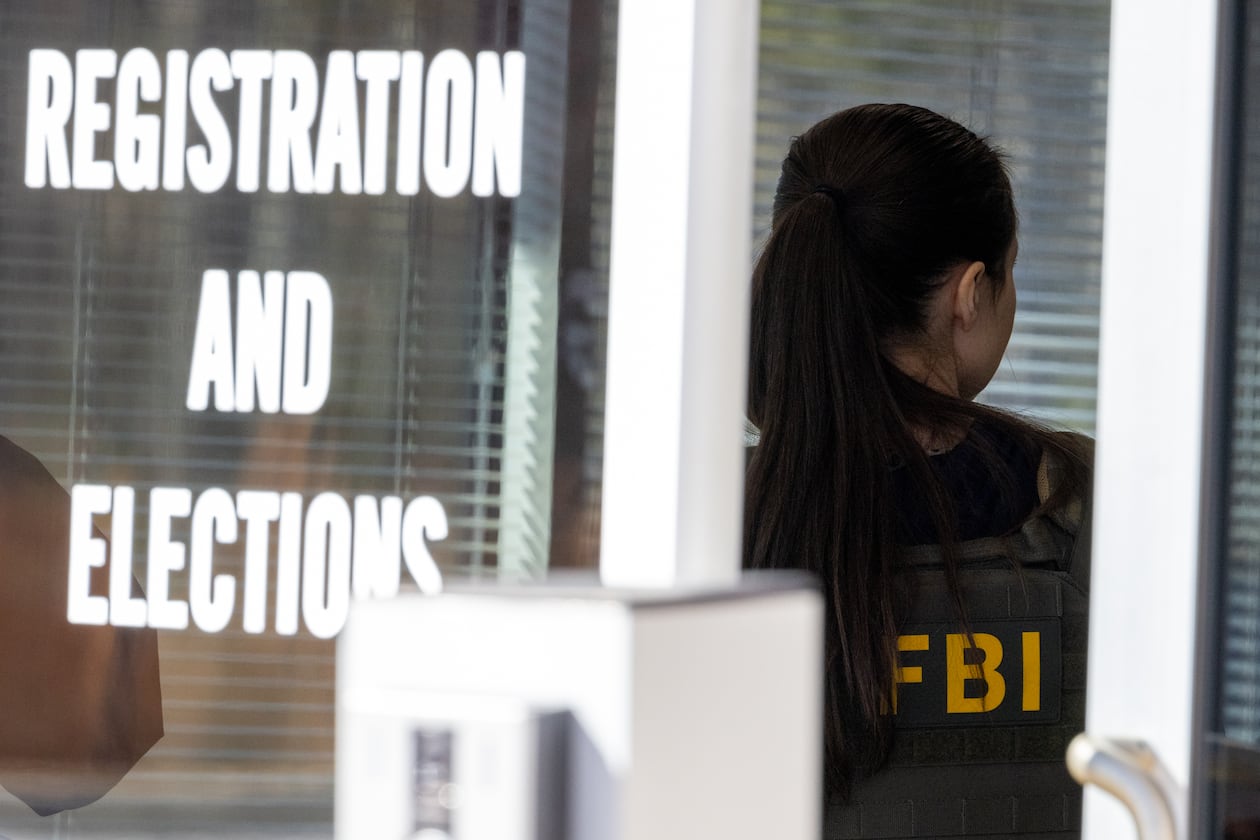 An FBI agent stands inside the entrance to the Fulton County Election Hub and Operation Center in Union City in January. (Arvin Temkar/AJC)