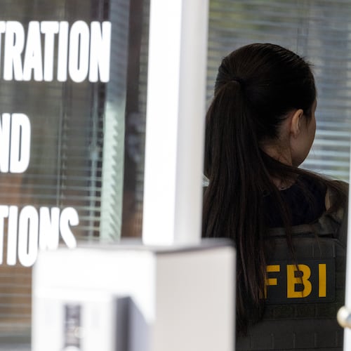 An FBI agent stands inside the entrance to the Fulton County Election Hub and Operation Center in Union City in January. (Arvin Temkar/AJC)
