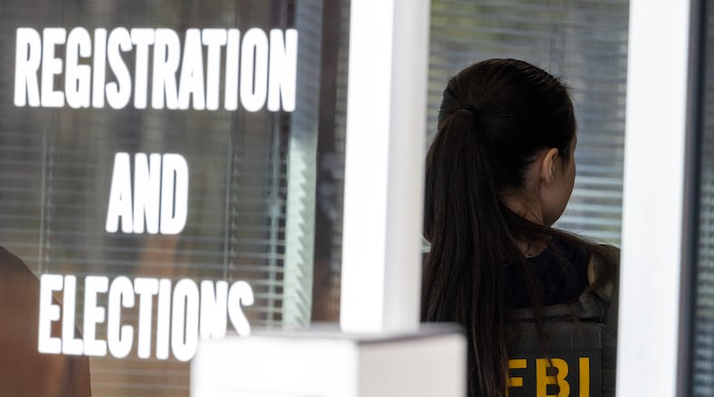 An FBI agent stands inside the entrance to the Fulton County Election Hub and Operation Center in Union City in January. (Arvin Temkar/AJC)