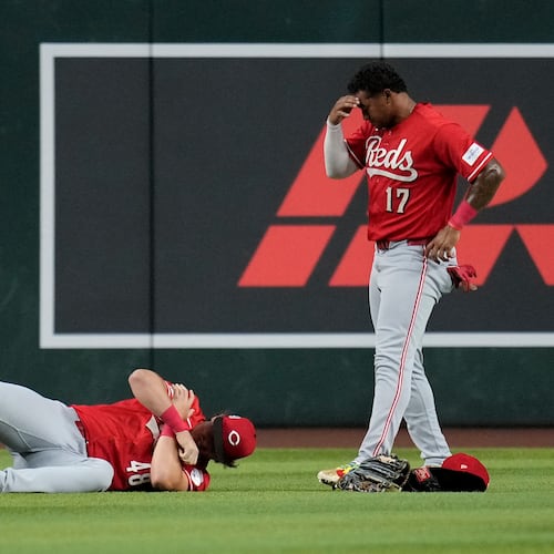 An injured Cincinnati Reds left fielder Michael Toglia (48) holds his shoulder as Reds center fielder Dane Myers (17) looks on during the first inning of a baseball game against the Arizona Diamondbacks, Friday, Aug. 21, 2026, in Phoenix. (AP Photo/Ross D. Franklin)