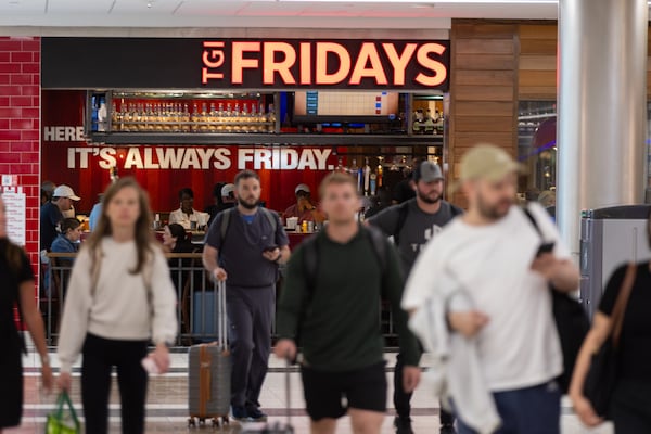 Travelers walk through a food court inside Concourse B at Hartsfield-Jackson Atlanta International Airport. In 2023, the airport announced Atlanta’s own Slutty Vegan would be coming to Concourse B. But less than two years later, those plans have fallen apart. (Arvin Temkar/AJC)
