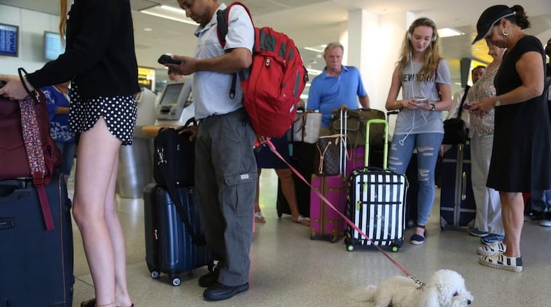 A dog named Jazzy waits in line with Delta Air Lines passengers at a ticket counter in Newark Liberty International Airport in Newark, N.J., on Aug. 8, 2016. The airline announced new rules Jan. 19, 2018, dealing with animals flying with passengers as service or emotional-support animals.