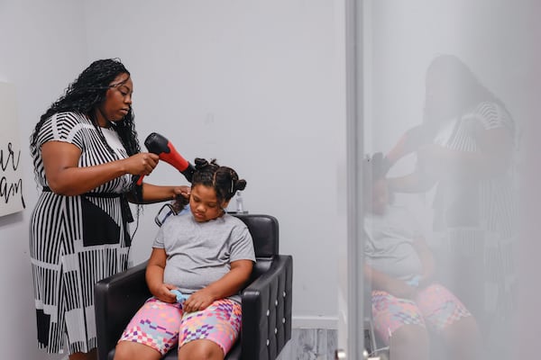 Thanks to The Higher Salon program, rising third grader Layla Brown (in chair) was able to get her hair done before the school year begins by Mallorye Crowell at Lux Studio Salon Suites in Atlanta on Monday, Aug. 4, 2025. (Natrice Miller/AJC)