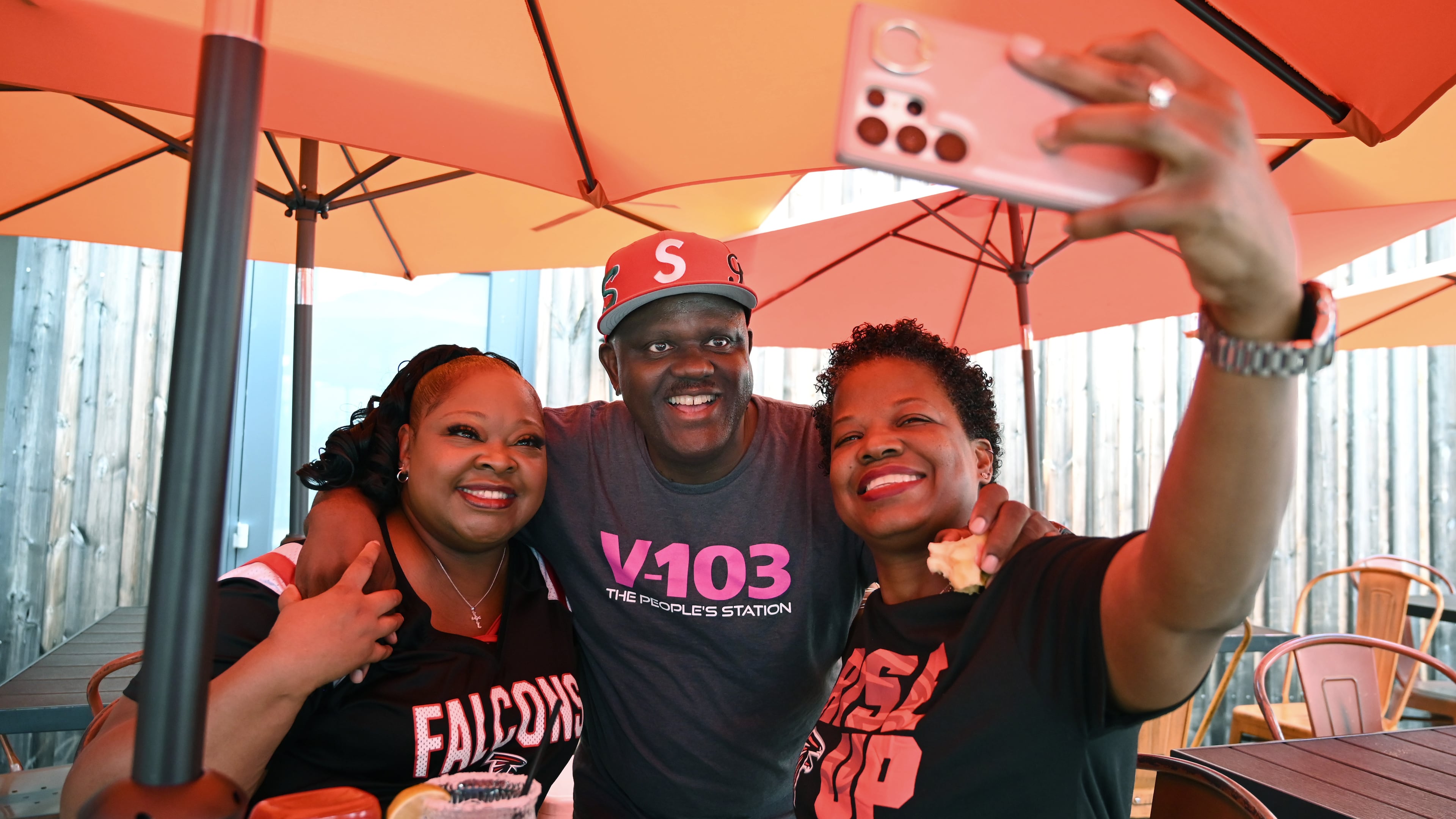 Greg Street (center), hip-hop DJ and radio personality, takes a selfie with fans Melinda Bailey (left) and Janice Bonner at Hobnob Neighborhood Tavern before an Atlanta Falcons pep rally at Atlantic Station, Friday, September 5, 2025, in Atlanta. (Hyosub Shin/AJC)