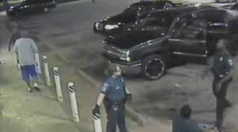 A frame capture from a store video shows DeKalb County Police Officer Demetrius Kendrick, right, and another officer with Alphonso Eleby, seated, seconds before Kendrick claimed that he found loose marijuana on the ground near Eleby.