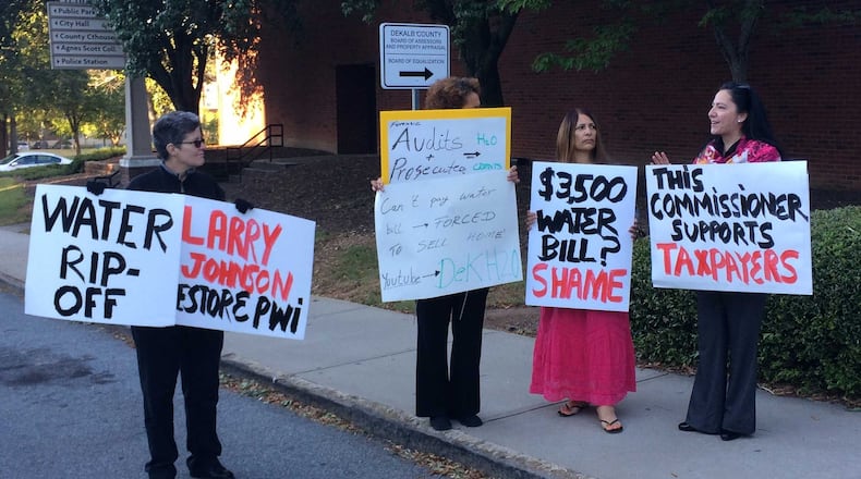 DeKalb County residents protest high water bills outside the county government center on Tuesday, Oct. 11, 2016. From left: Hope Lusignan, Anita Connor, Judy Knight and Commissioner Nancy Jester hold signs calling for the county government to fix the problem. MARK NIESSE / MARK.NIESSE@AJC.COM