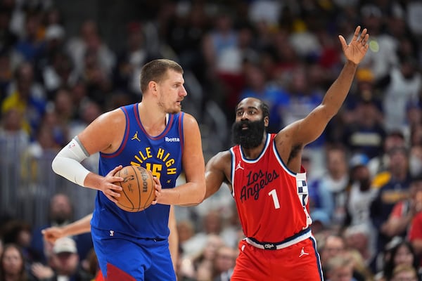 Denver Nuggets center Nikola Jokic, left, looks to pass the ball as Los Angeles Clippers guard James Harden, right, defends in the second half of Game 7 of an NBA basketball first-round playoff series Saturday, May 3, 2025, in Denver. (AP Photo/David Zalubowski)