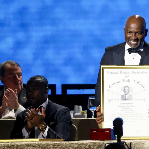 Former New Mexico wide receiver Terance Mathis holds up his College Football Hall of Fame Award during the National Football Foundation Awards Dinner, Tuesday, Dec. 5, 2023, in Las Vegas. (AP Photo/Ian Maule)
